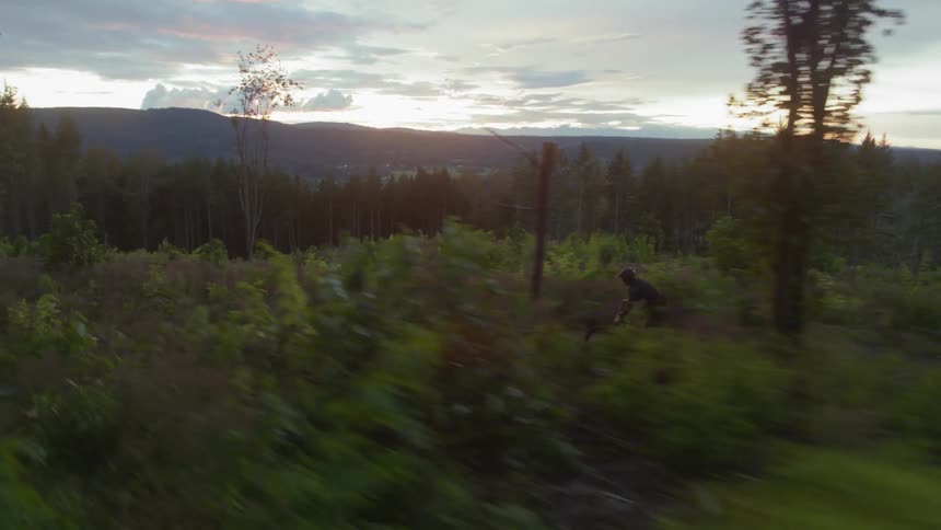 Man riding mountain bike on the hill at dawn