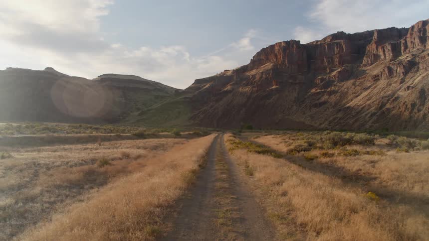 A road on a grass land and canyon