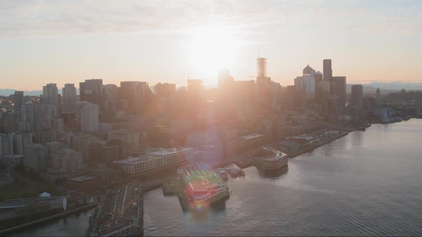 Sun shines through buildings in the city at sunset