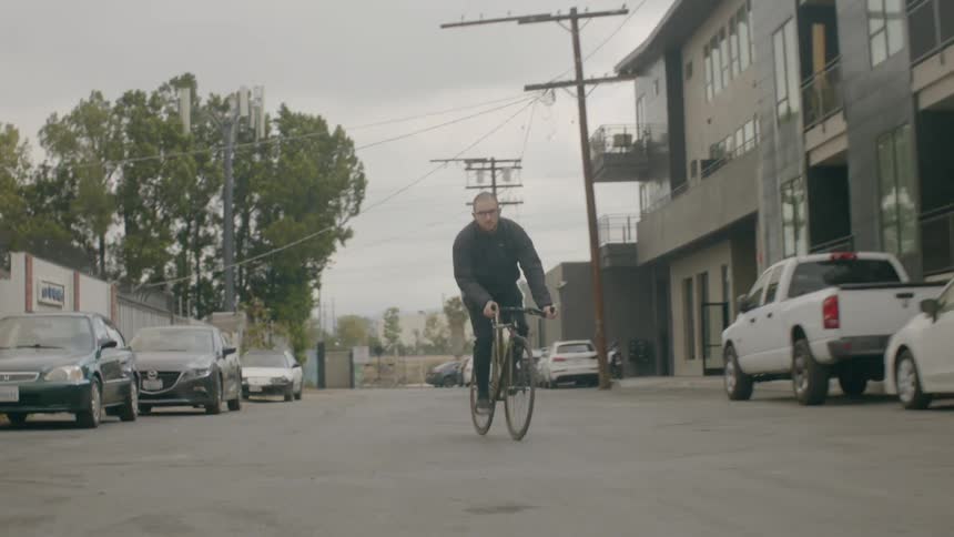 An man rides his bike down the city street