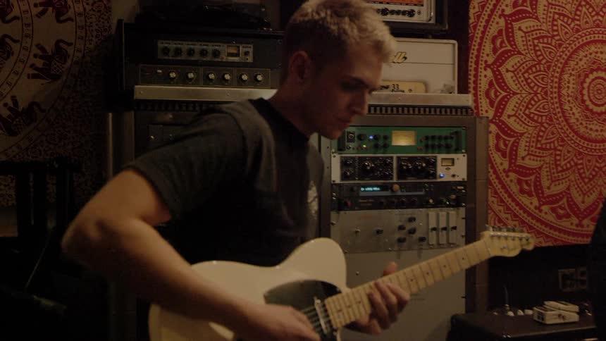 A person is playing guitar in a room