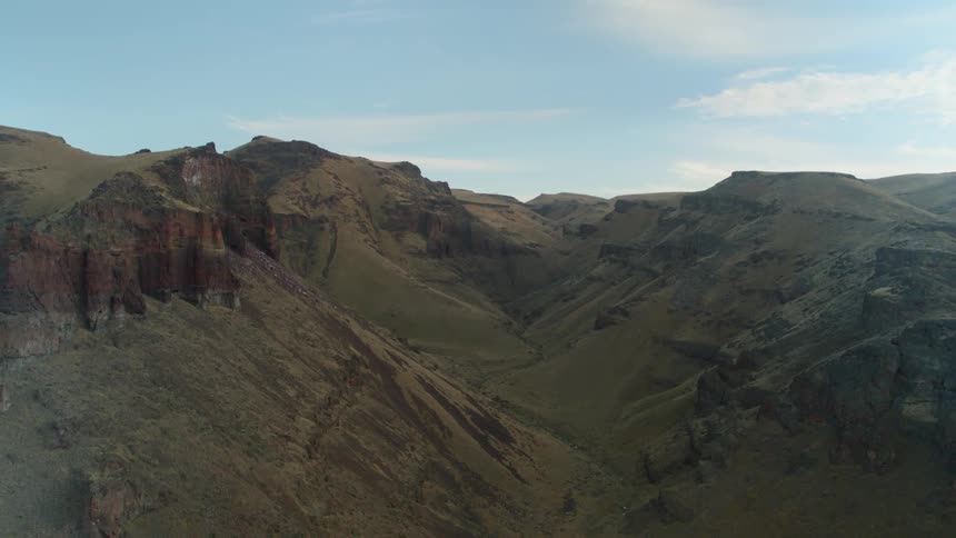 A canyon with the sky and clouds in the background