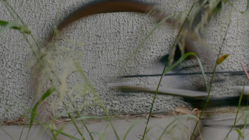 A bicycle quickly traveling down a pathway near a wall