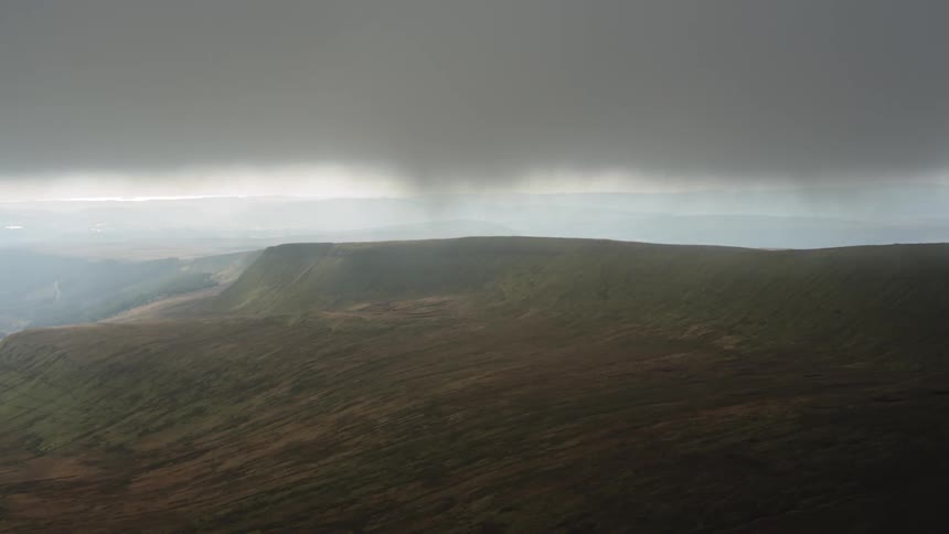 A view of a mountain with a heavy cloud above them