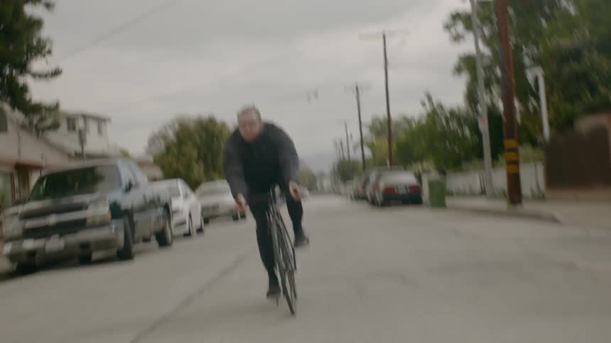 A man rides his bike down a neighborhood street