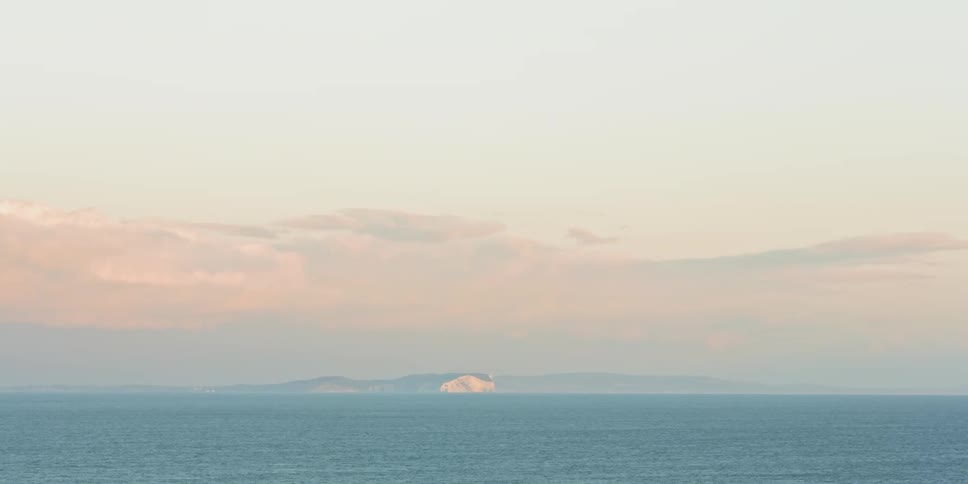 Land is seen in the distance across a vast body of water