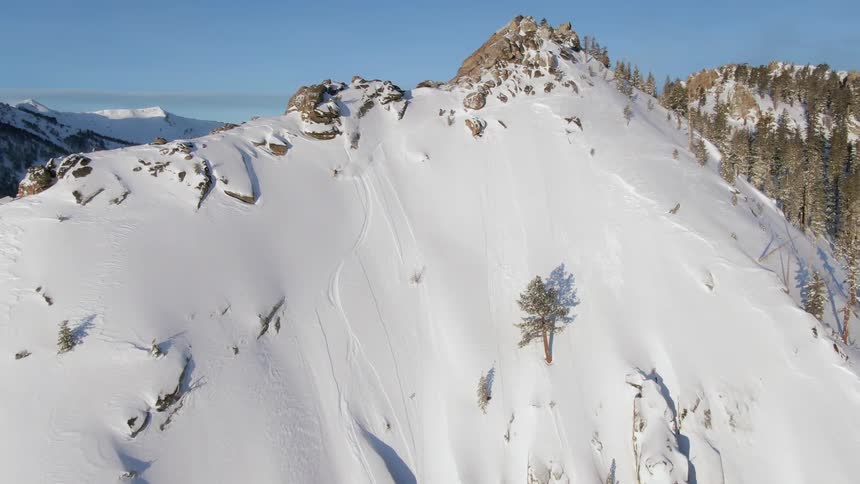 A person is skiing down the steep mountain