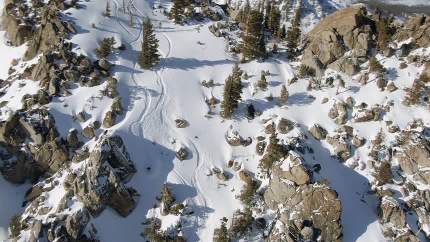A person is snowboarding down the mountain