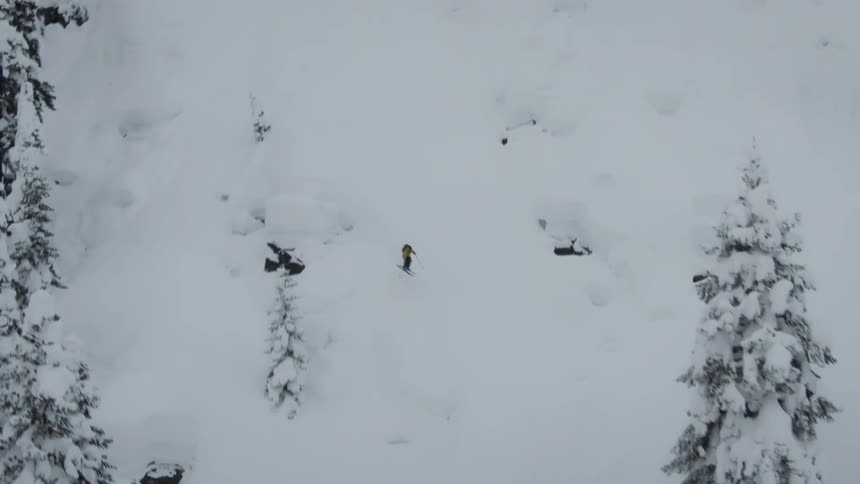 A person skiing down a tall rocky slope