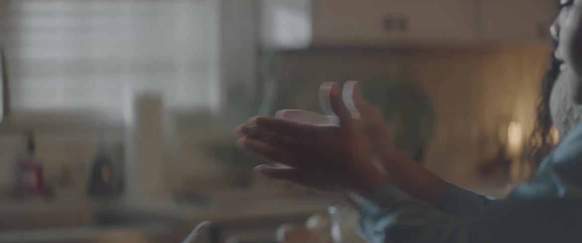 A child is clapping the flour off of their hands over a counter