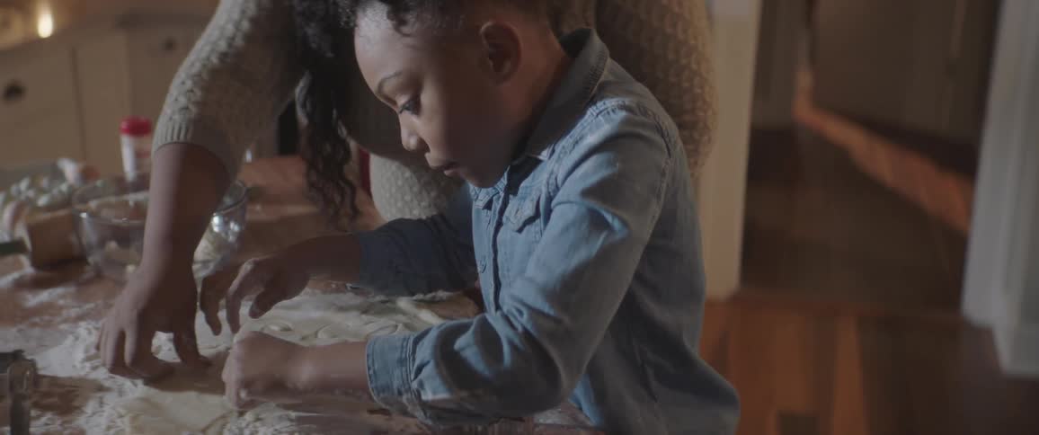 Woman helps a young boy do craftwork with clay