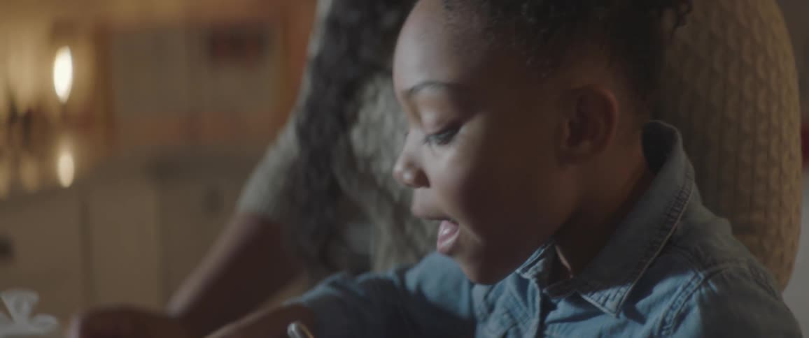 A young girl takes a bite of a cookie