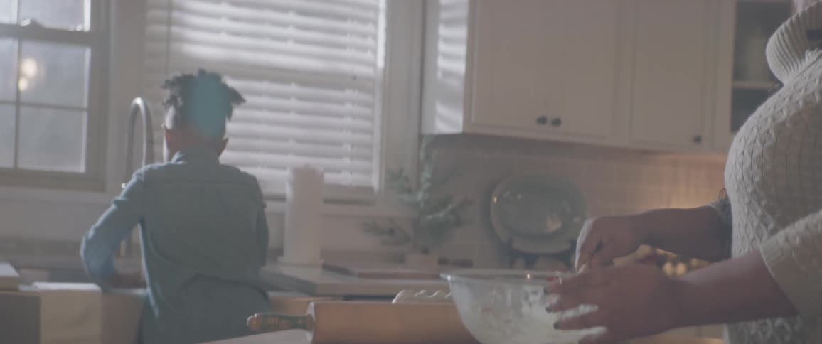 Girl helping her mother cook and washing dishes at the kitchen