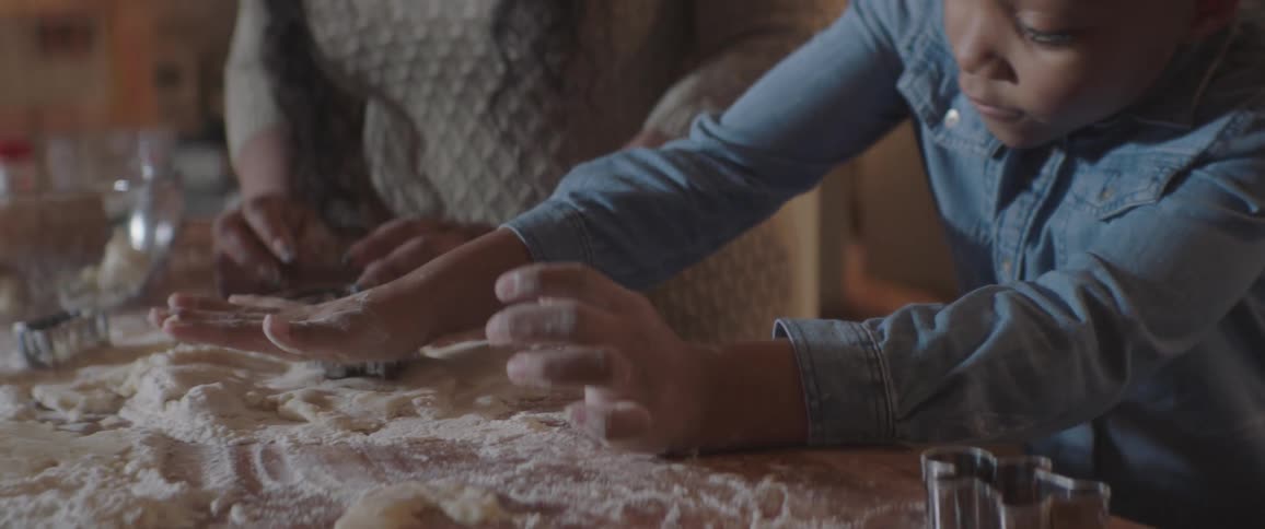 A girl cuts dough with a cookie cutter