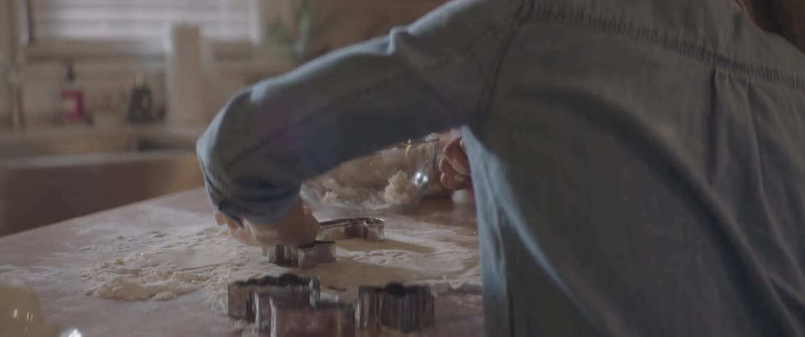 A woman and a girl cutting shapes into dough