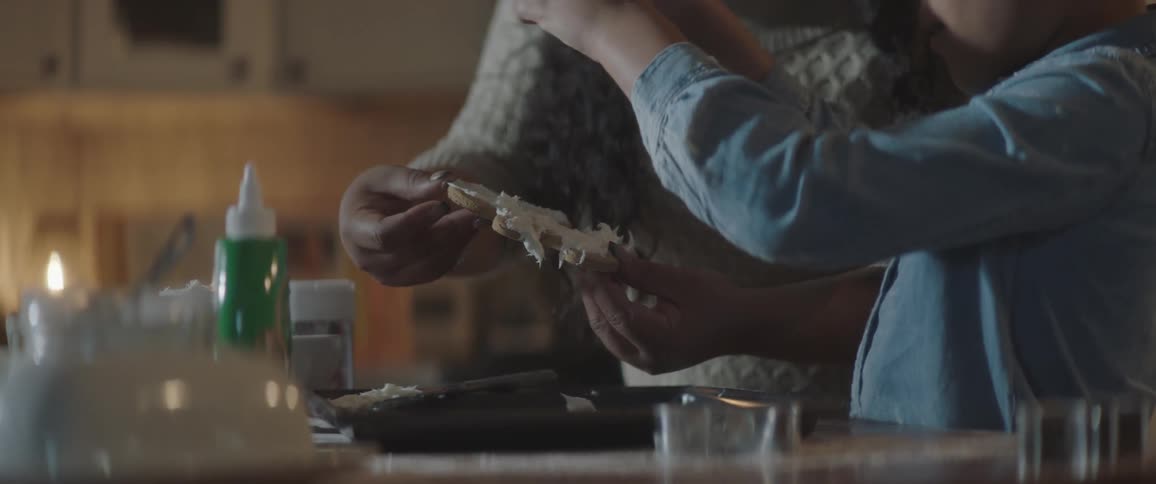 Woman and daughter are decorating cookies