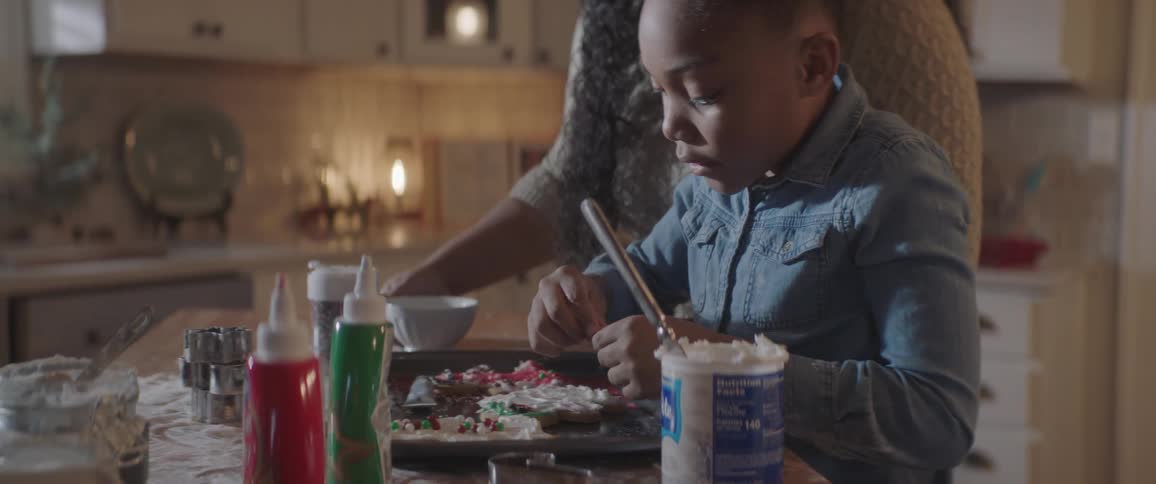 A woman and a girl decorating cookies