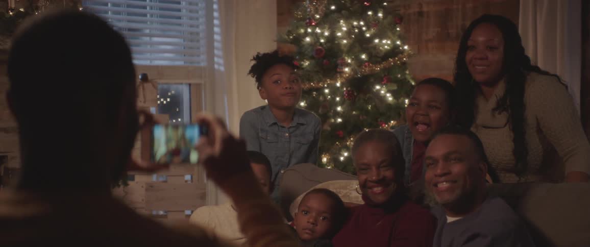 A family poses for a photo in front of a christmas tree