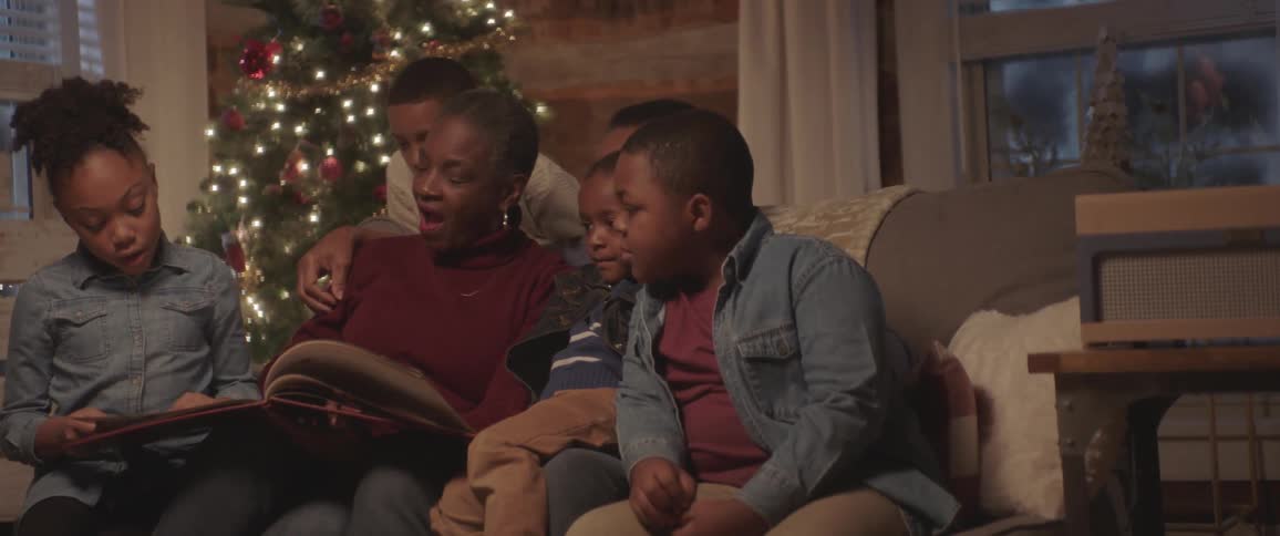 A family reads a book at the holidays