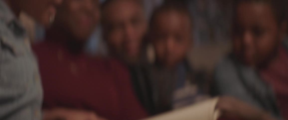 Family sits on sofa reading a book