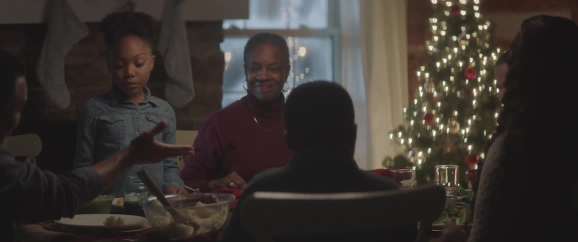 A family sits around a table laughing and eating