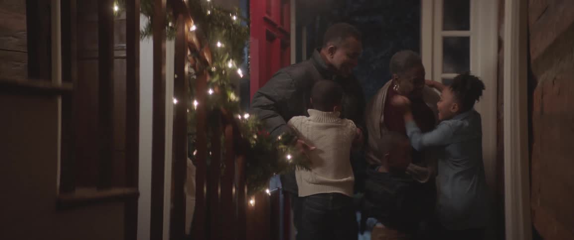 A family hugs in the entry way to a house
