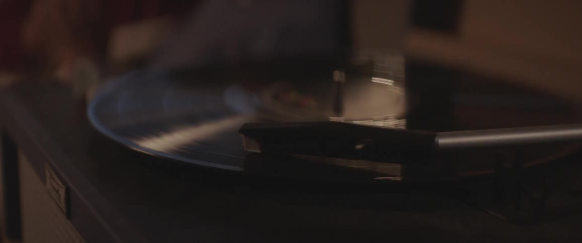 Couple cuddling while a vinyl disc being played