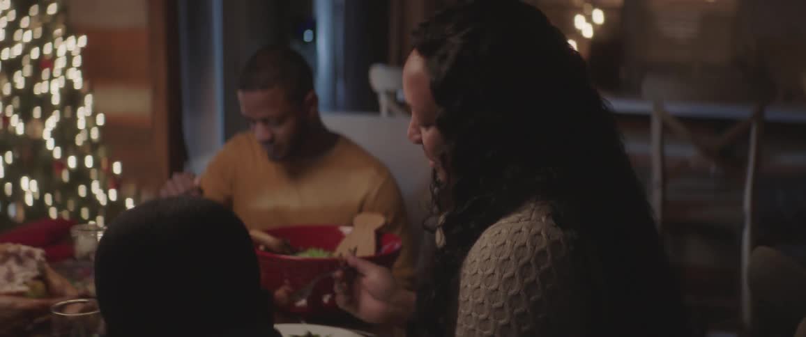 Black family sitting at the table has christmas dinner at home