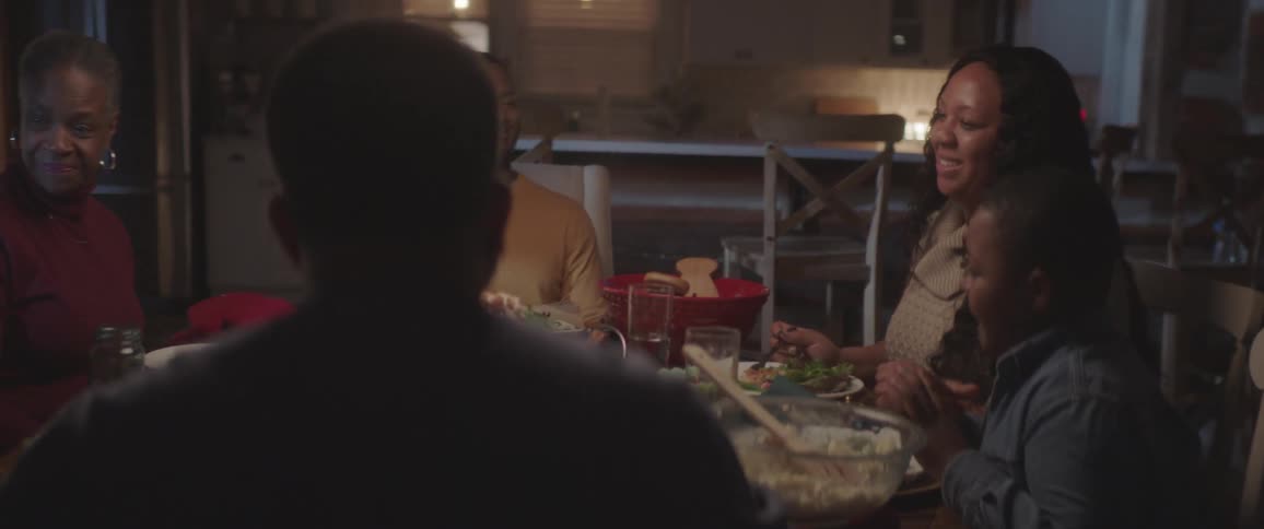 People sitting at a table talking and laughing while enjoying a meal
