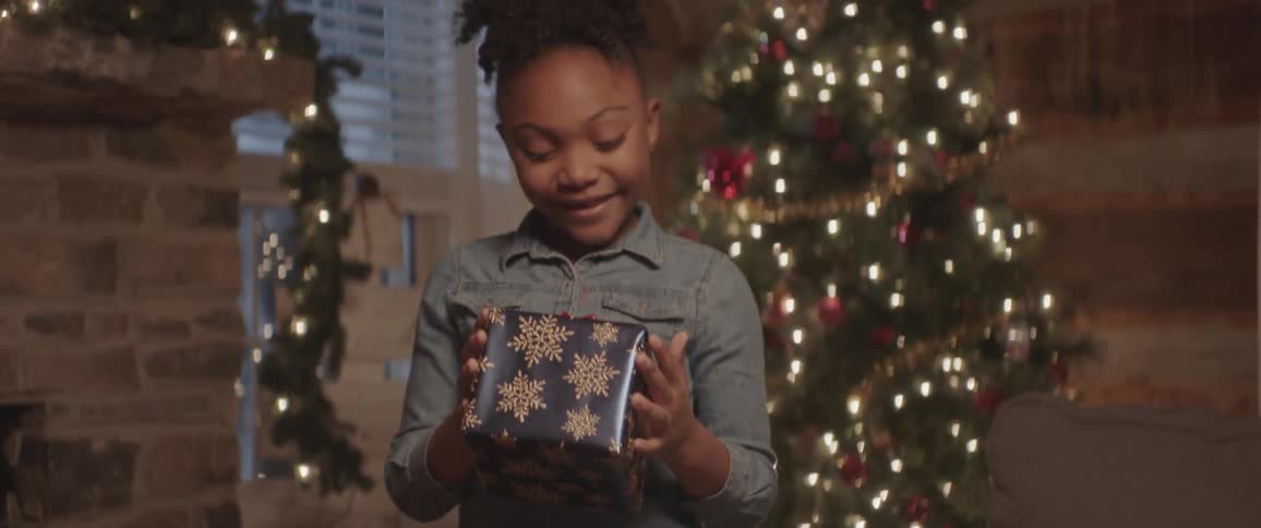 A girl is excited to receive a present inside on a christmas day