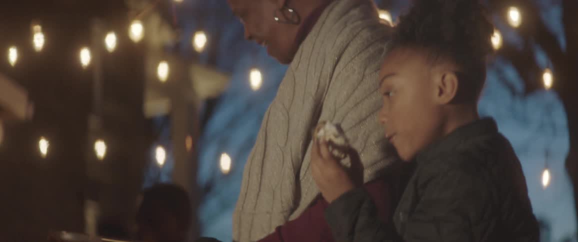 Daughter and mother cuddling at the garden under christmas light