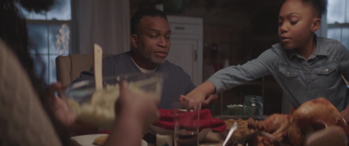 A family sitting around a dinner table with a turkey in the middle of the table