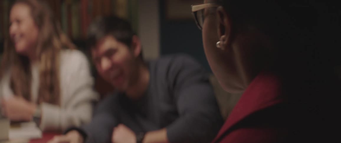 A group of friends are sitting at a table and laughing together