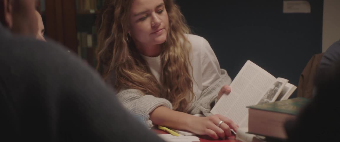 Woman explains book to others in study group
