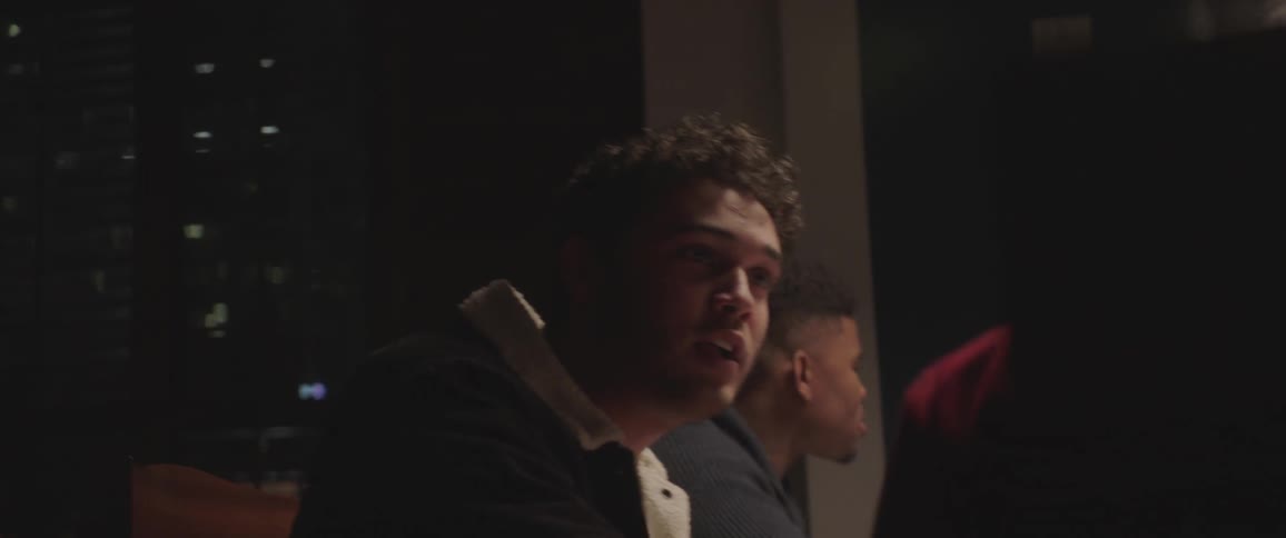 A man is talking to a person beside him at a table