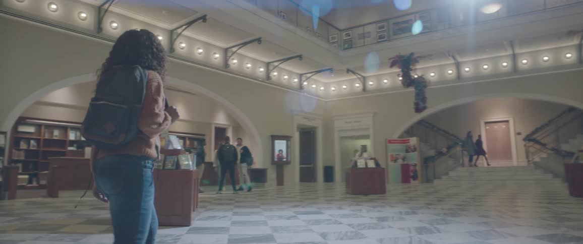 Girl with a bag walking in the library hall