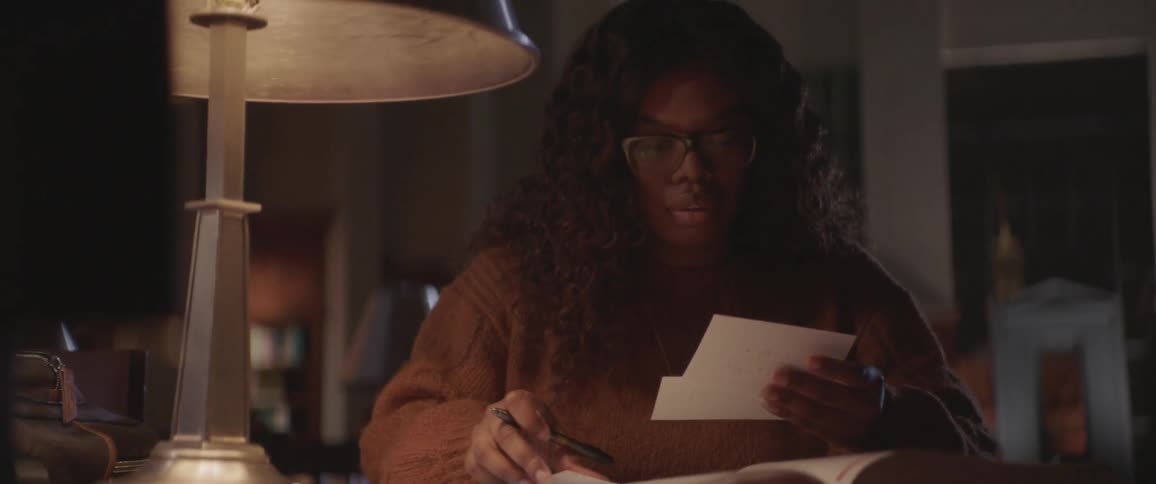 A woman is looking at note cards indoors
