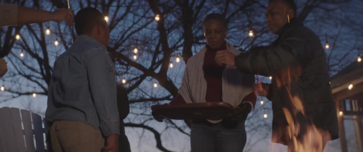 A family cooking marshmallow at the campfire