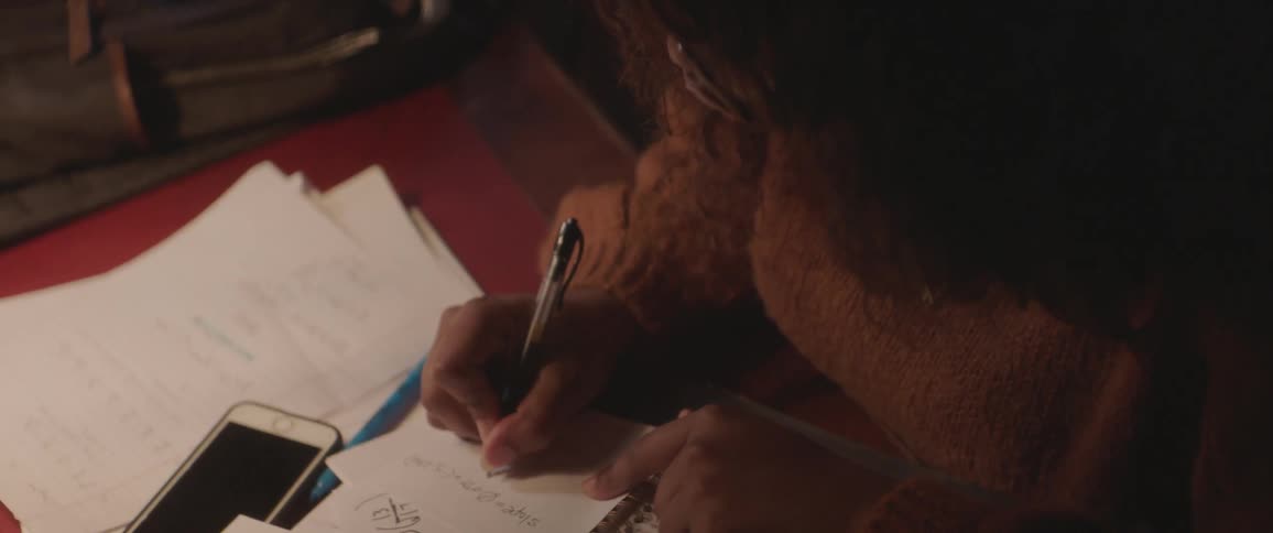 Woman writing on a paper with a black pen