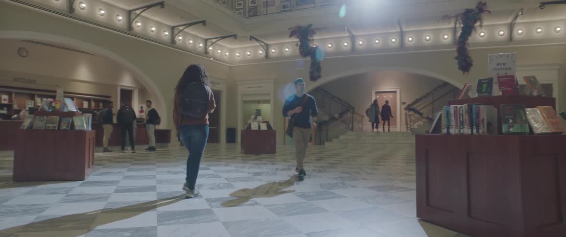 People walk through the lobby of a large library