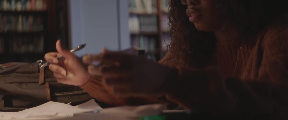 A woman is reading note cards in the library