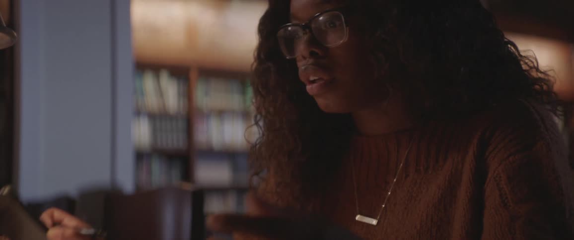 A woman is frustrated after looking at her phone in a library