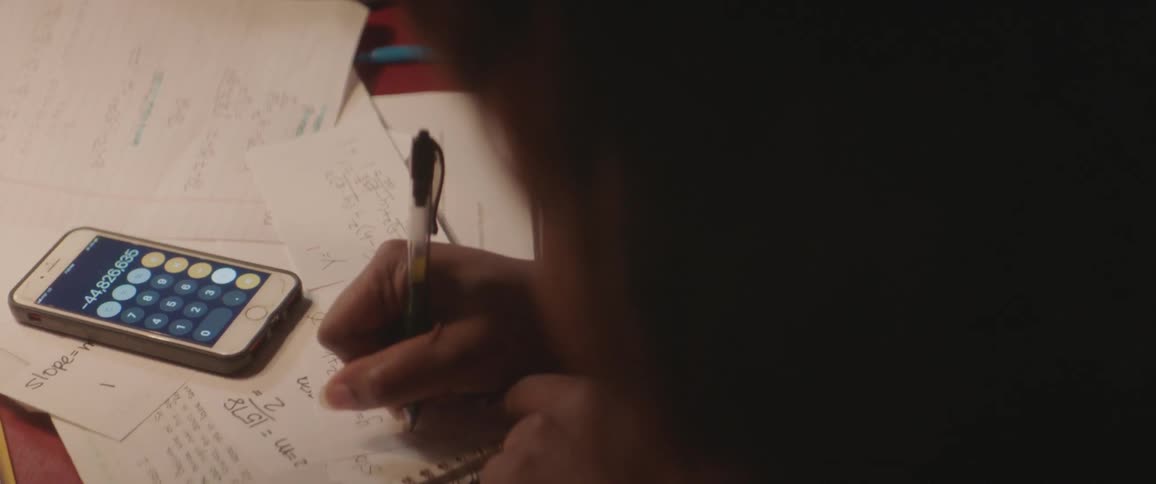 Black woman sitting at the table writes down in the library