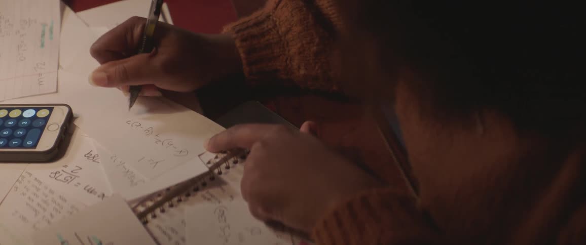 Woman writing a formula on a paper