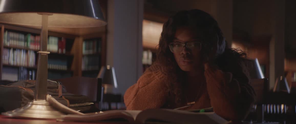Woman nervously going through a book while studying at a library