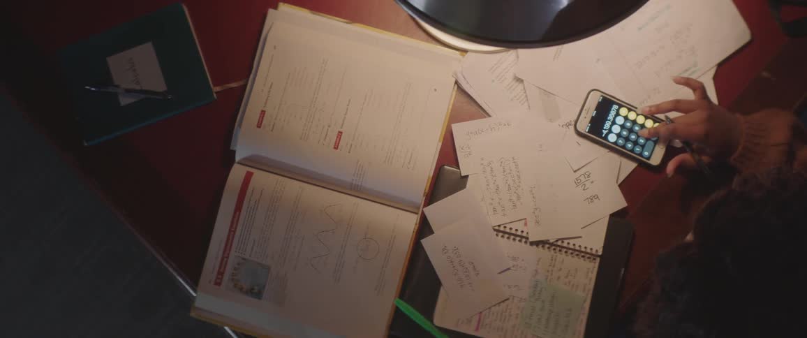 A student completes math homework at her desk