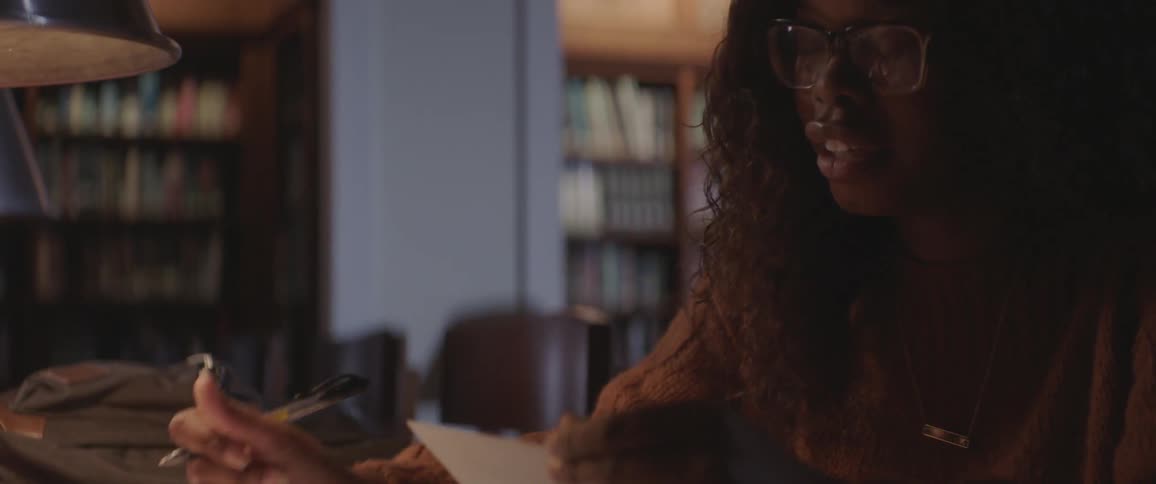 A woman looks at index cards and takes notes