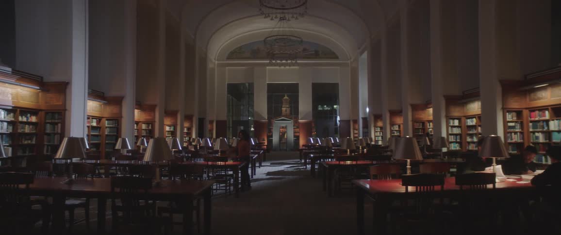 A young girl walks in to a dark library