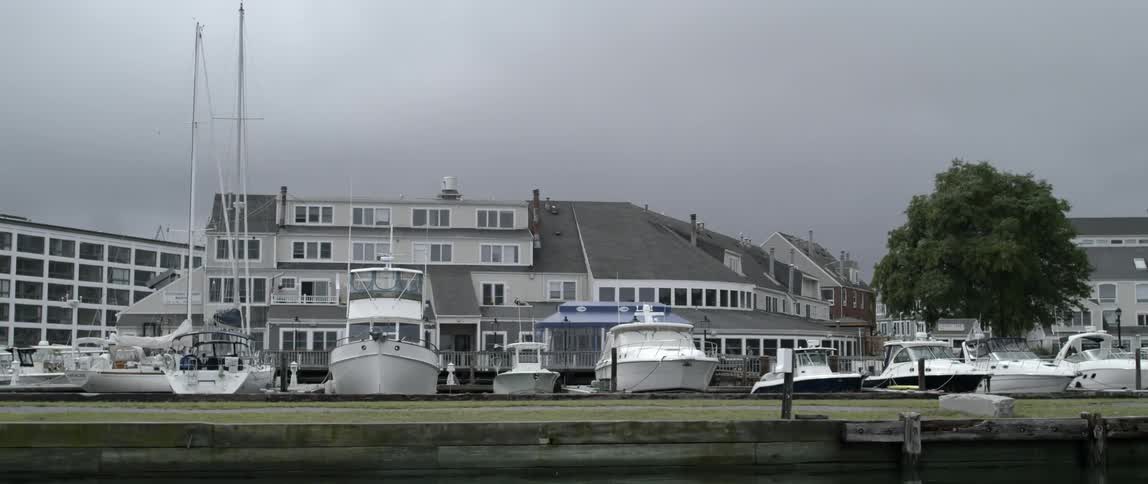 A row of boats at a marina on a cloudy day