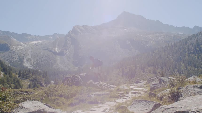 A man hikes along a path on a mountain
